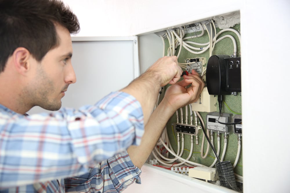 Electrician fixing cable in domestic electrical box